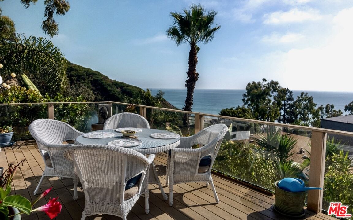 a patio with wooden floor table and chairs