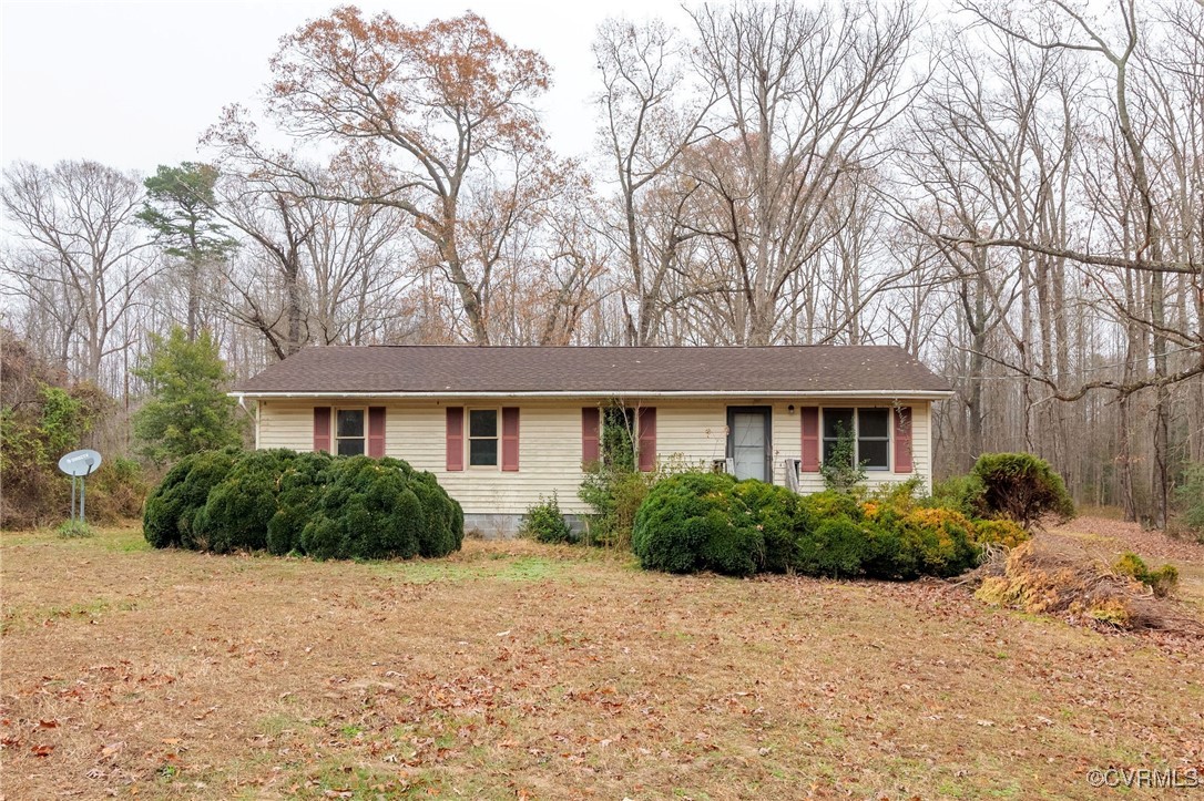 a front view of house with yard and trees around