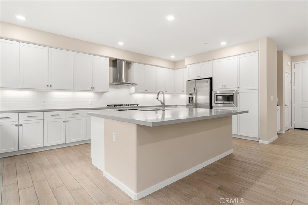 a kitchen with granite countertop white cabinets and stainless steel appliances