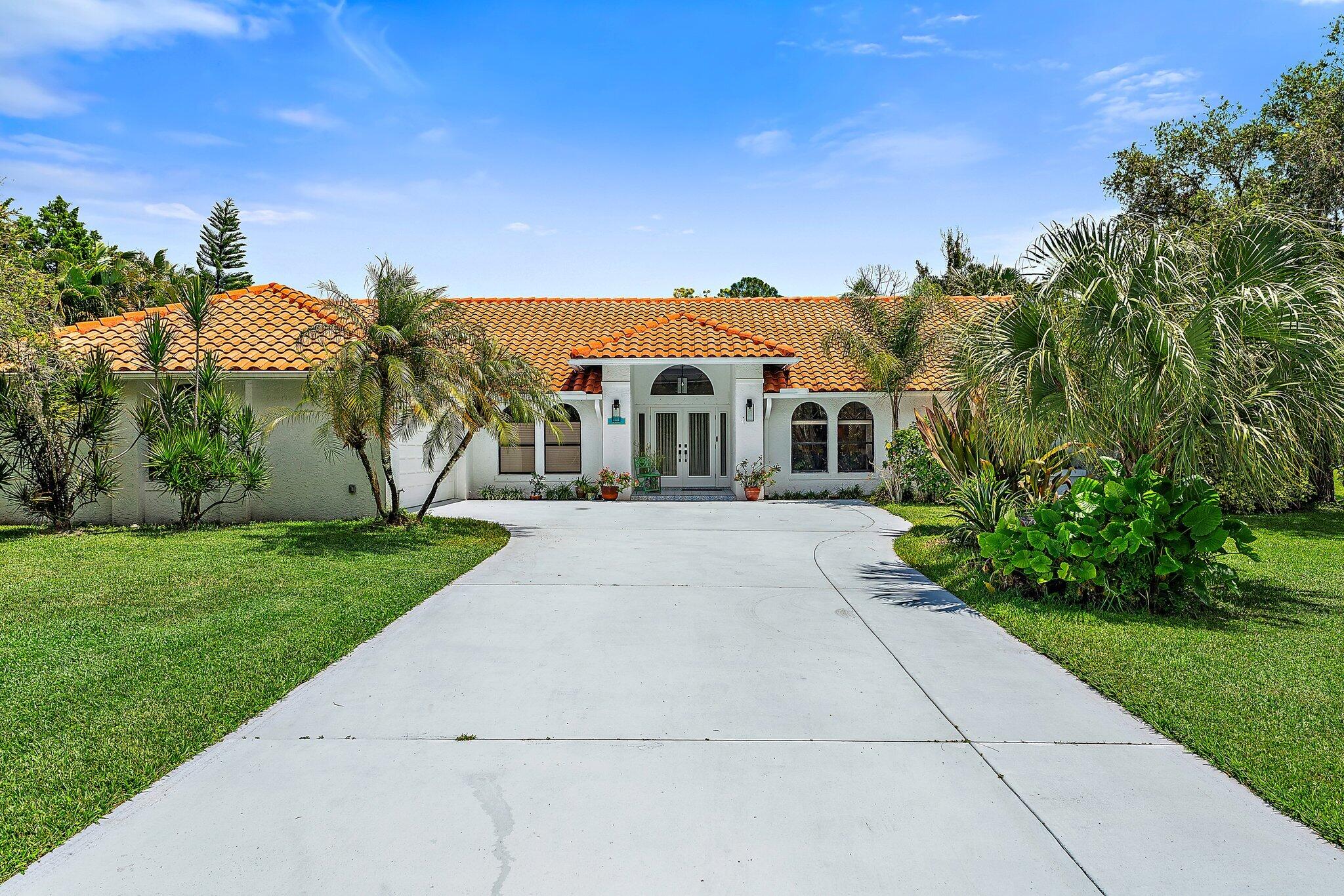 a front view of a house with a yard and trees