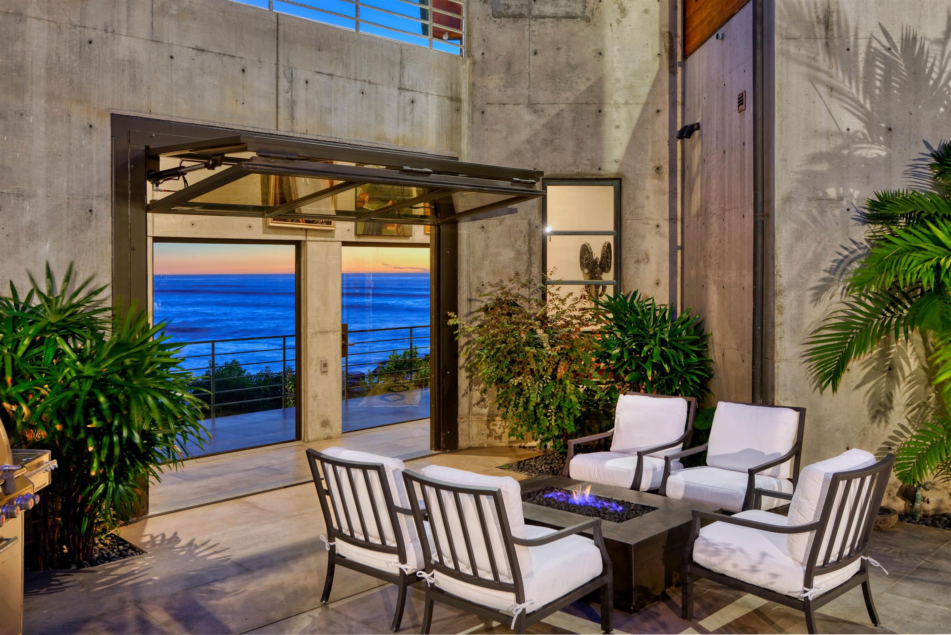 a view of a patio with table and chairs potted plants and palm tree