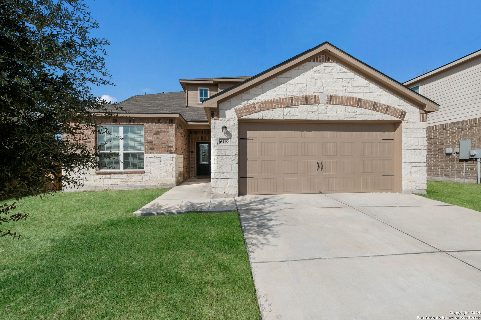 a front view of a house with a yard and garage