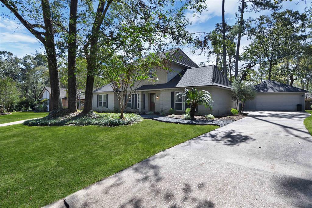 a front view of a house with a garden and tree