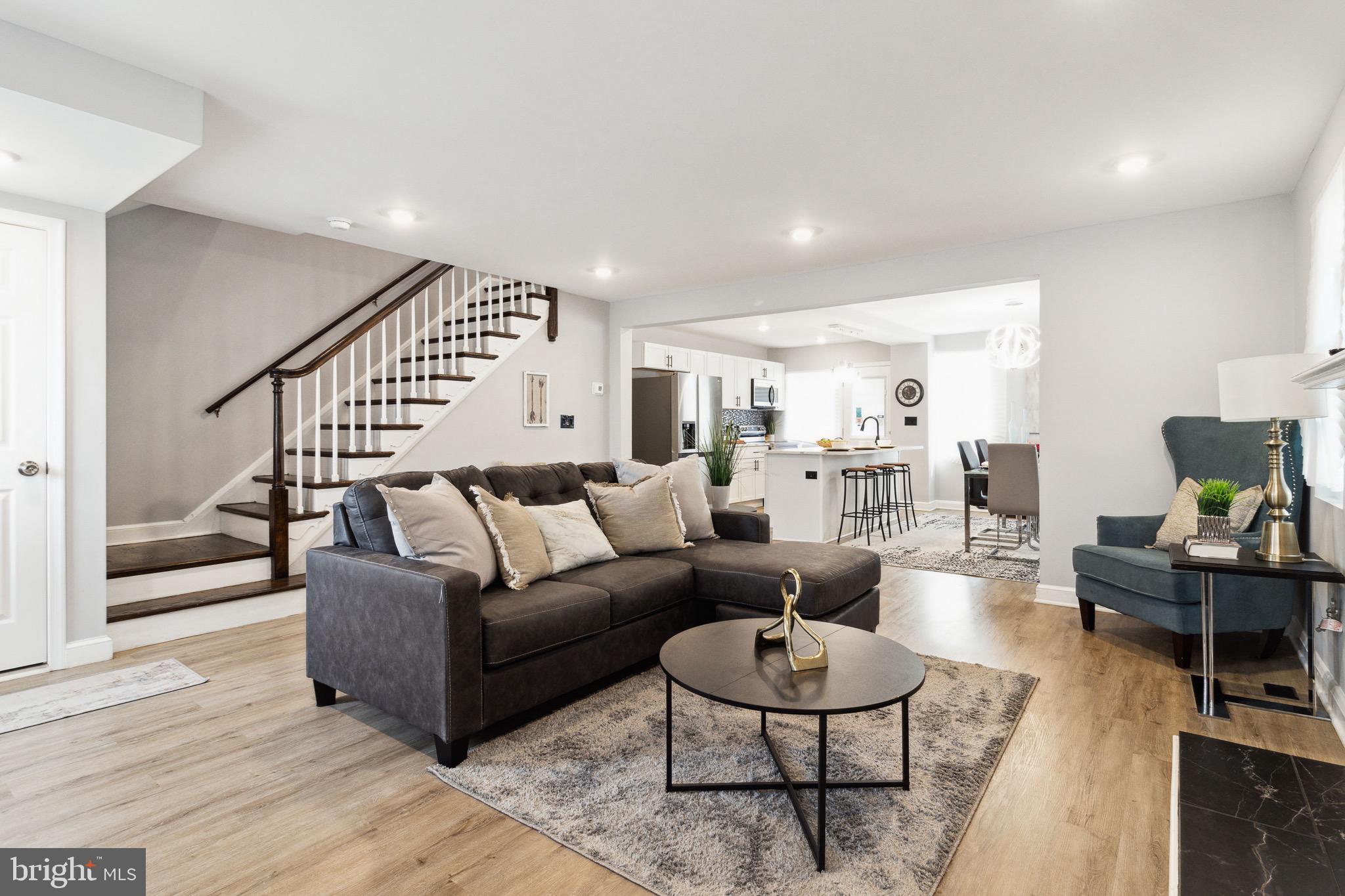 a living room with furniture and a wooden floor