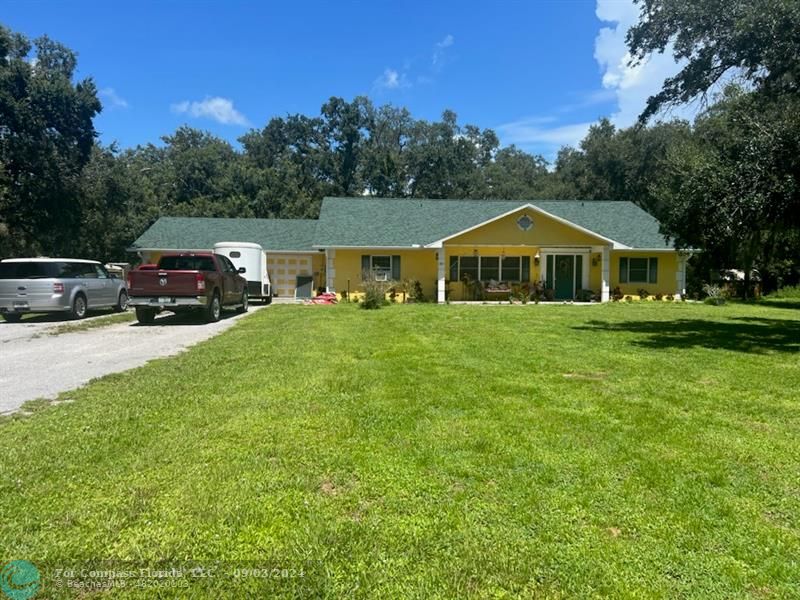 a front view of a house with a yard and trees