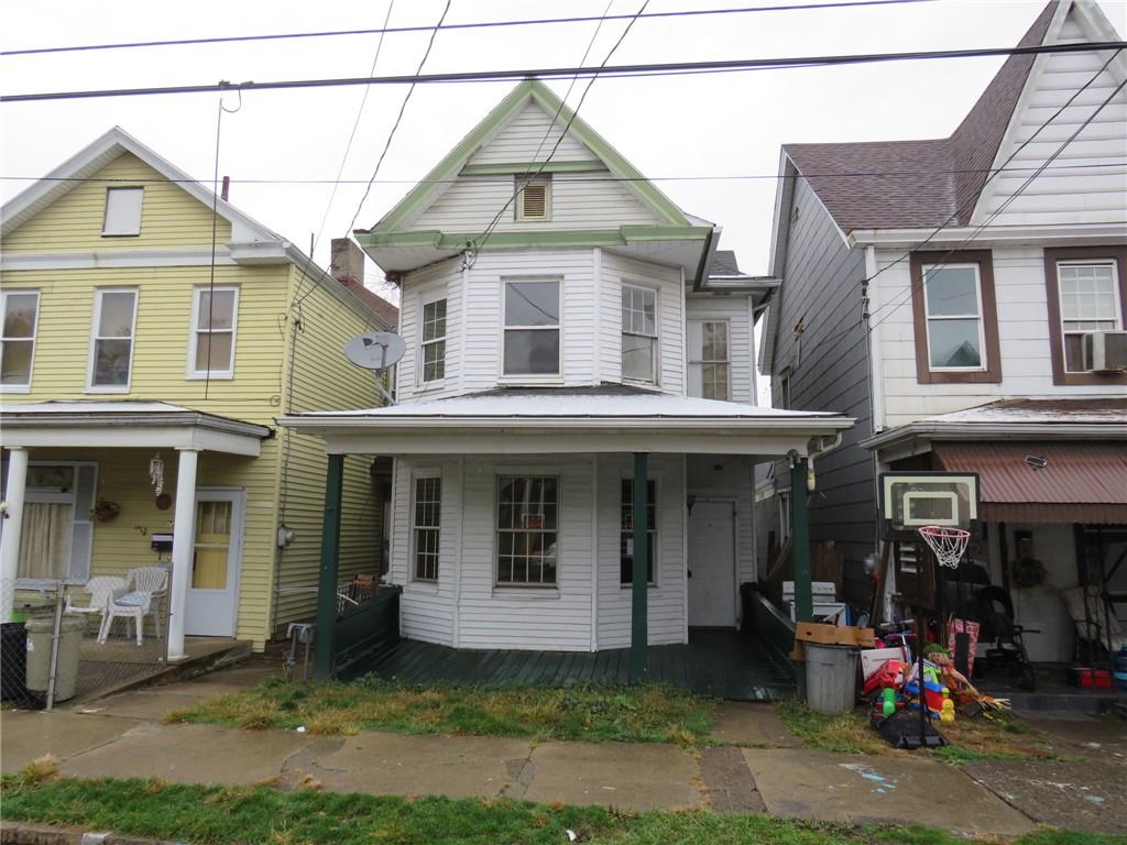 a front view of a house with a yard and potted plants