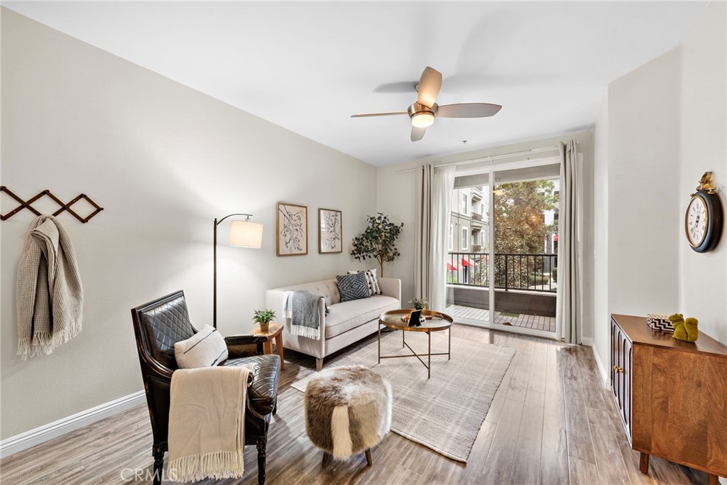 a living room with furniture large window and wooden floor