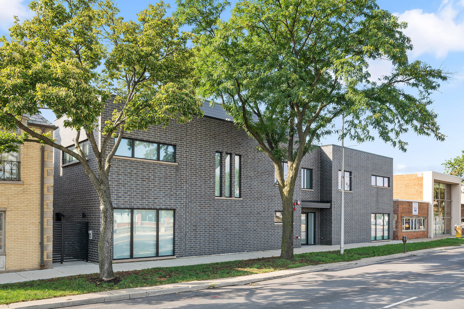 a front view of a house with a tree