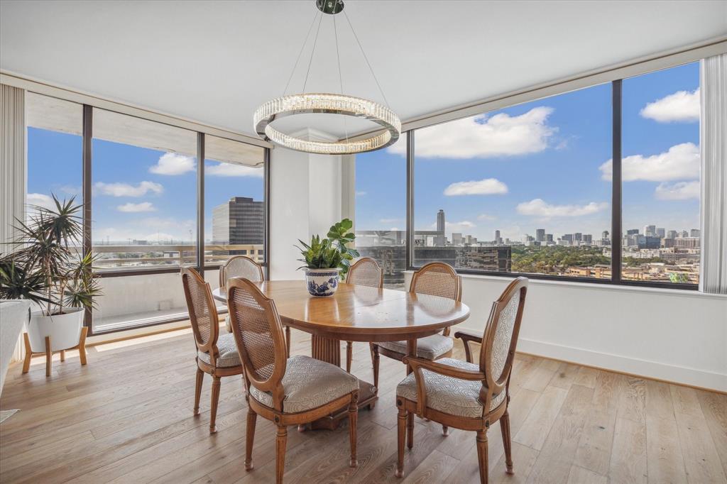 Contemporary dining room with floor-to-ceiling windows offering panoramic city views.