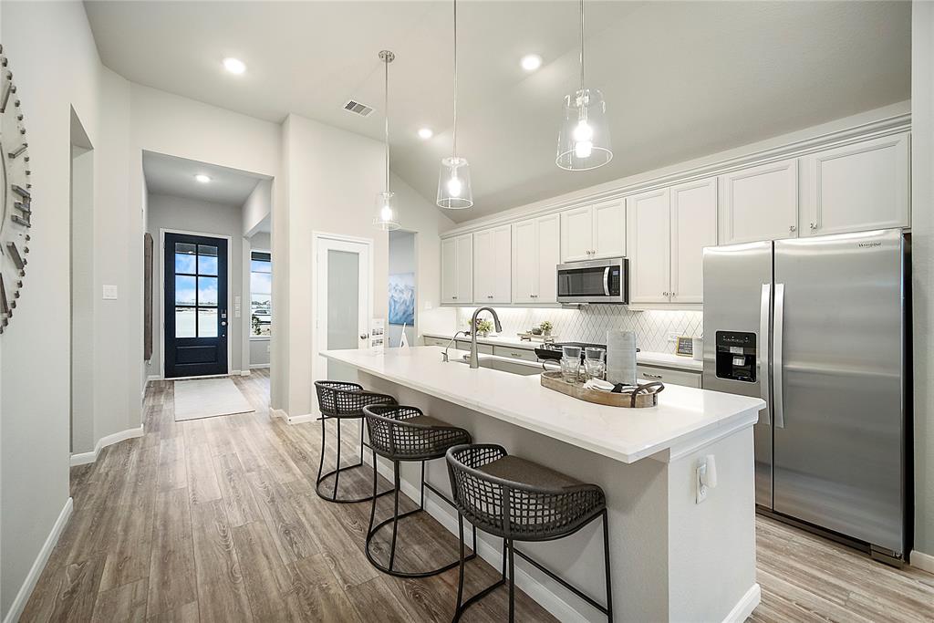 a kitchen with a sink a refrigerator a stove and cabinets