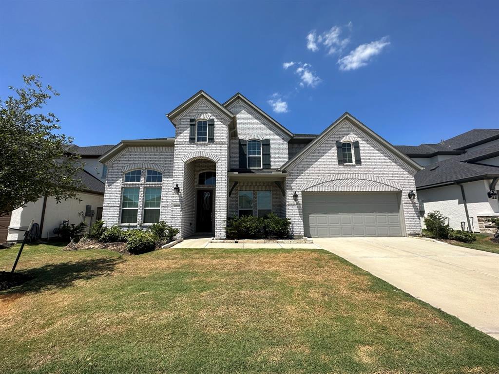 a front view of a house with a yard and garage