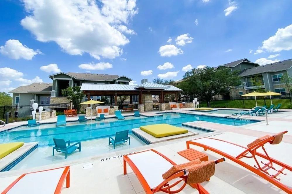 a view of a swimming pool with lounge chairs in patio