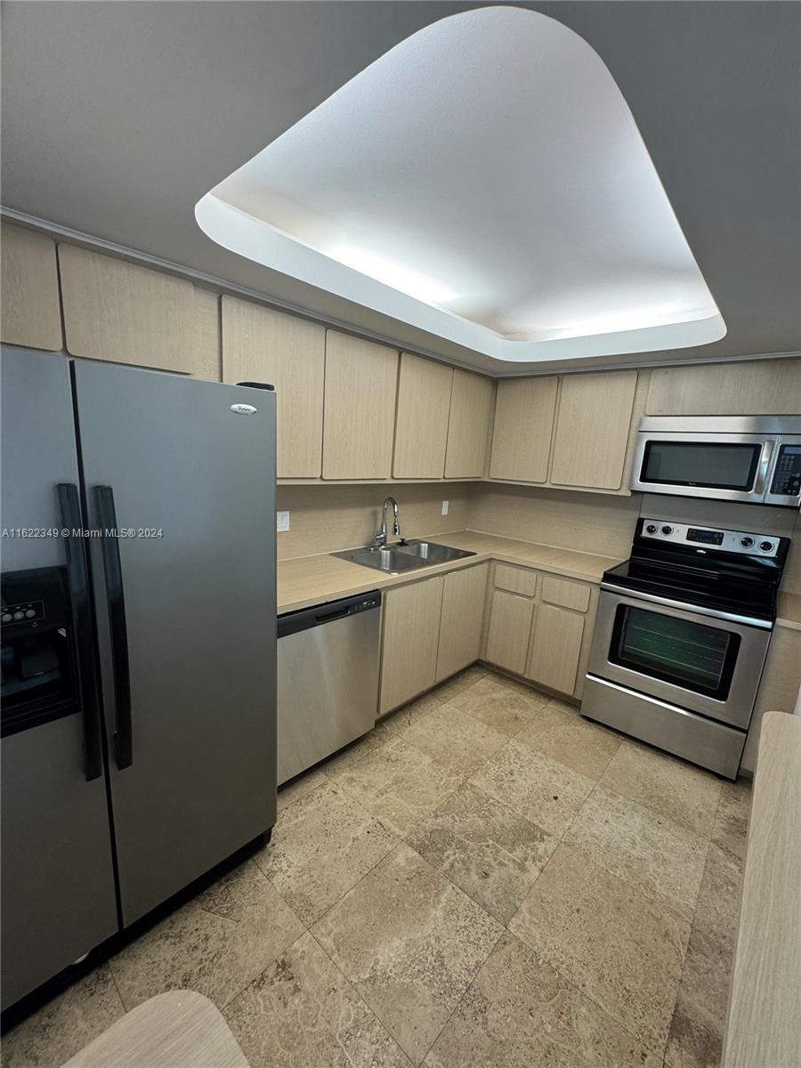 a kitchen with stainless steel appliances a refrigerator and a stove top oven