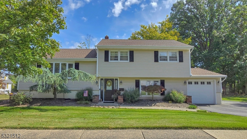 a front view of a house with a garden and yard