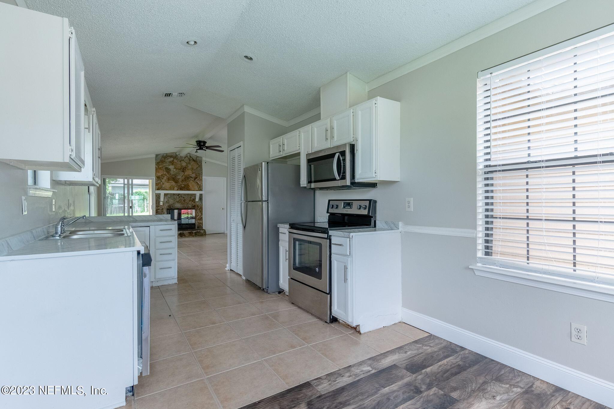 a kitchen with kitchen island a sink stainless steel appliances and cabinets