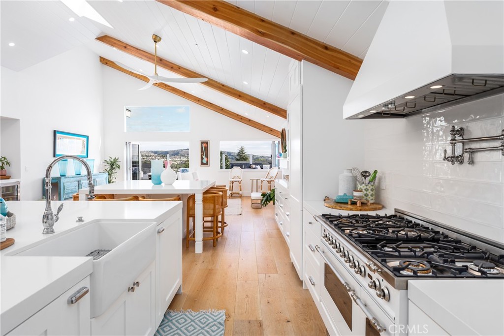 a large kitchen with a stove and wooden floor