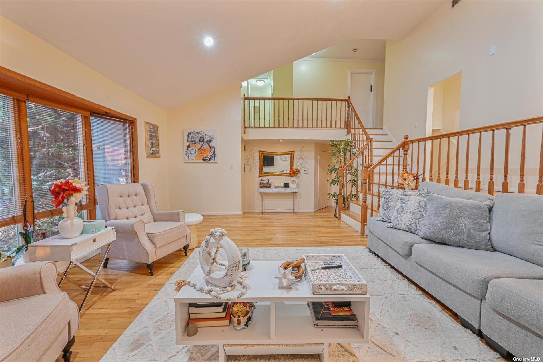 a living room with furniture kitchen view and a large window