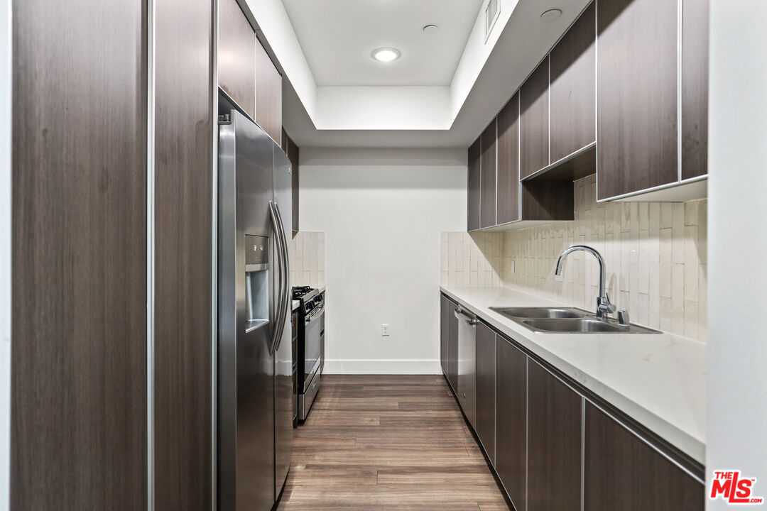 a kitchen with stainless steel appliances granite countertop a sink and refrigerator