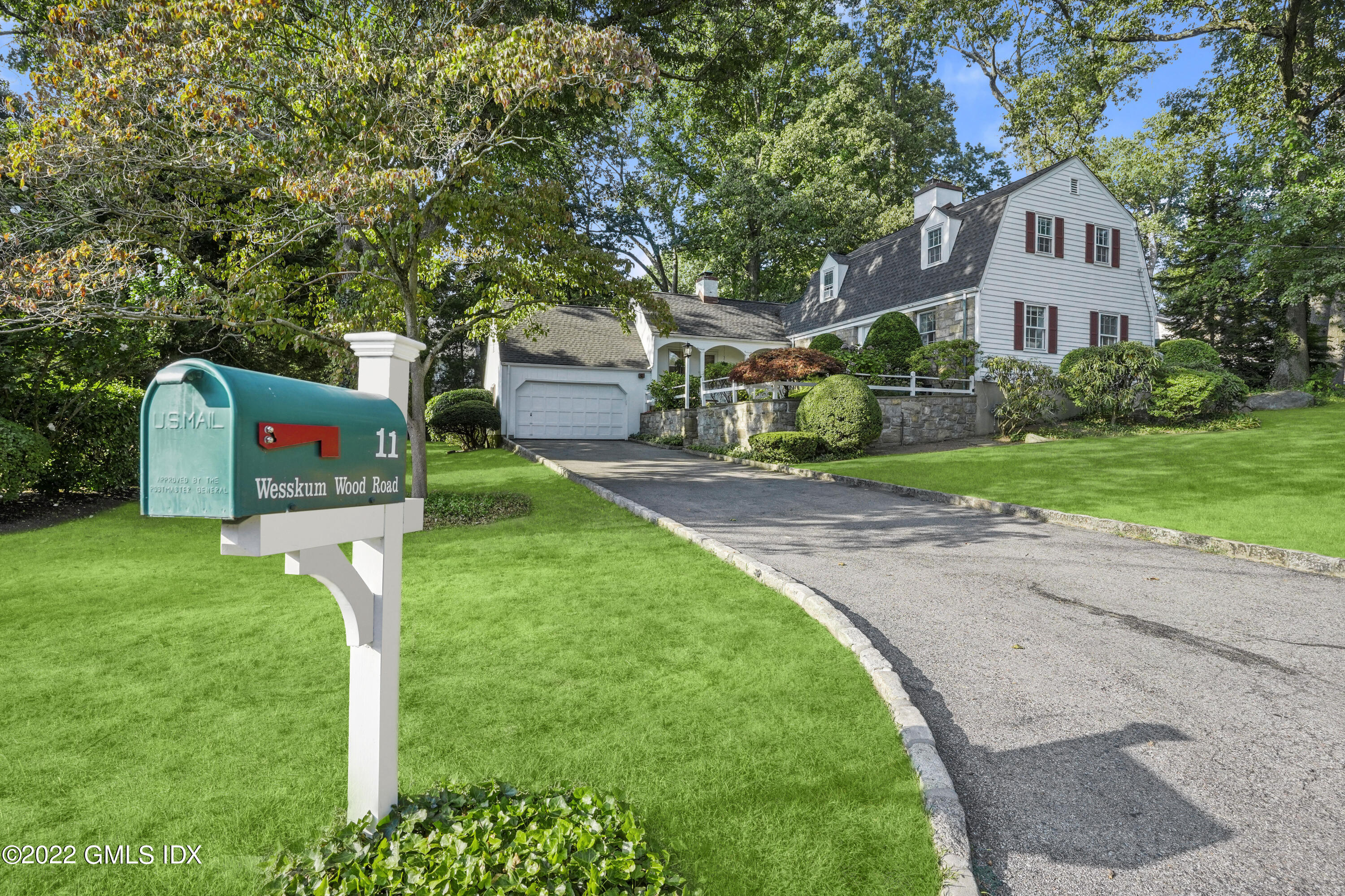 a front view of a house with a yard and tree