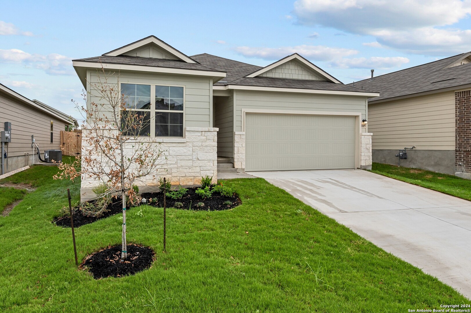 a front view of a house with a garden and plants