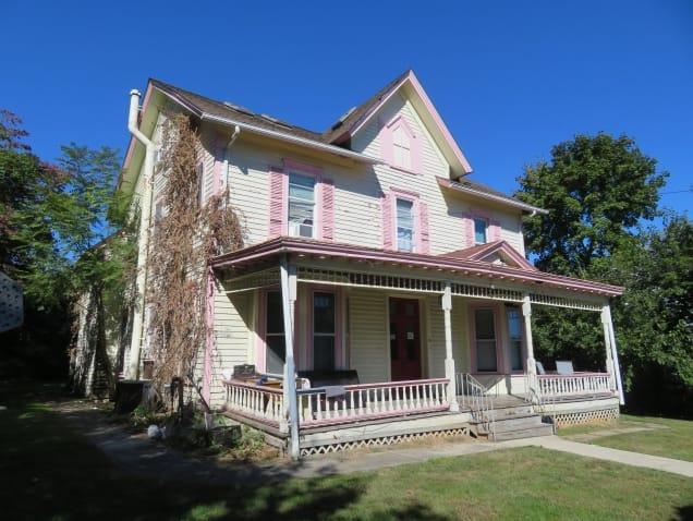 Victorian-style house with a front yard and a porch