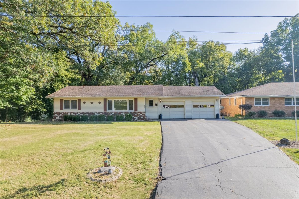 a front view of a house with a yard and trees