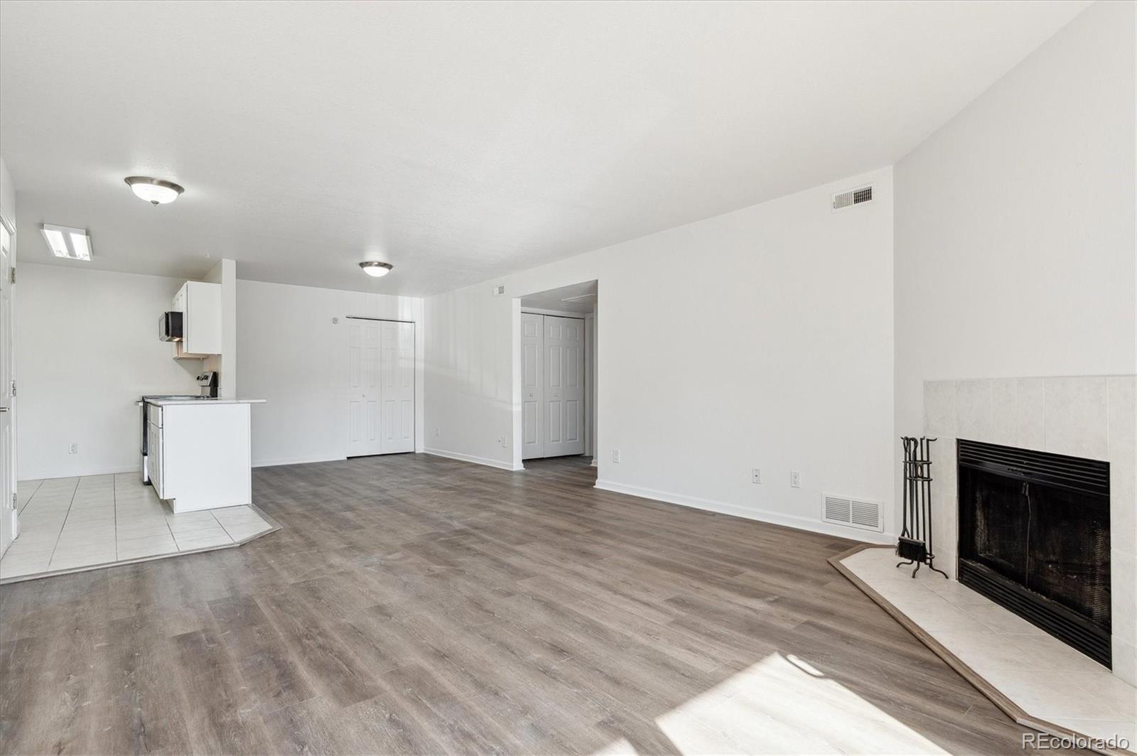 a view of empty room with wooden floor and fireplace