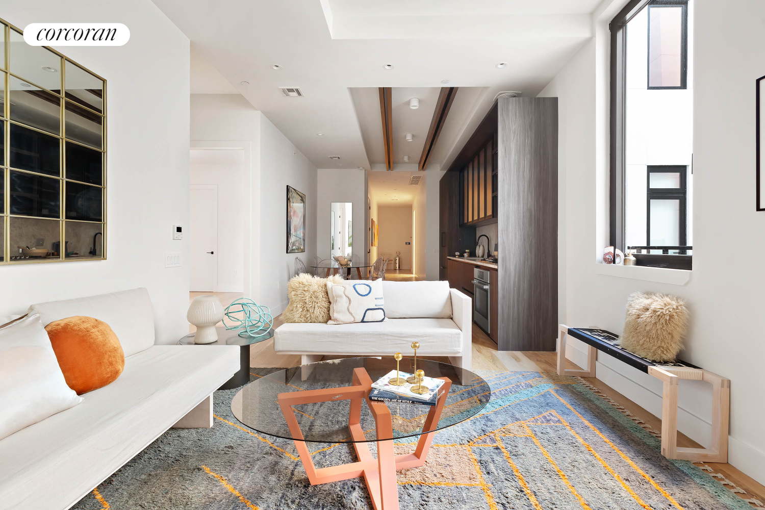 a living room with furniture potted plant and kitchen view