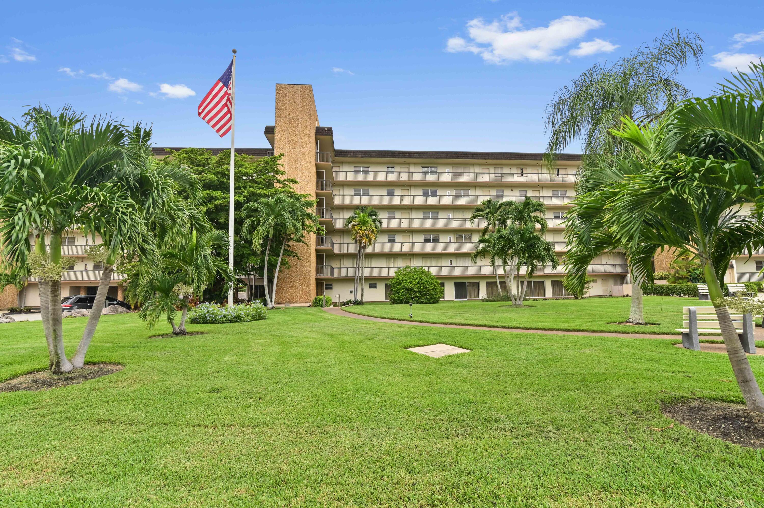 a view of a big building with a big yard and plants