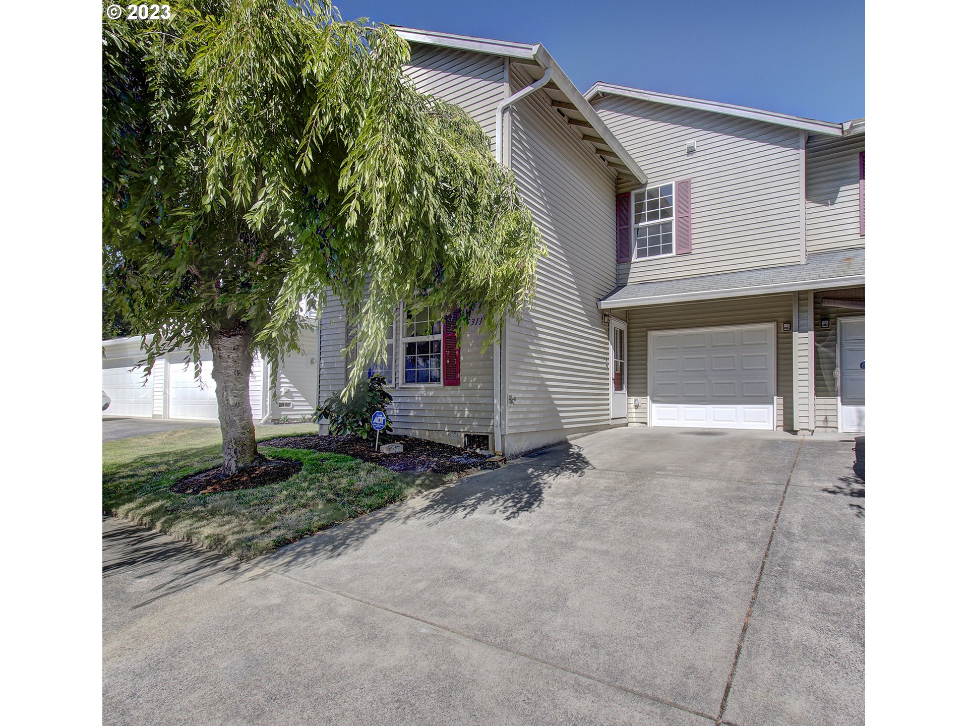 a view of a house with a yard and tree