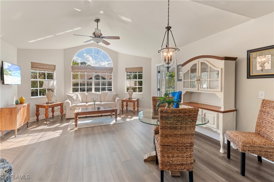 a dining room with furniture a chandelier and wooden floor