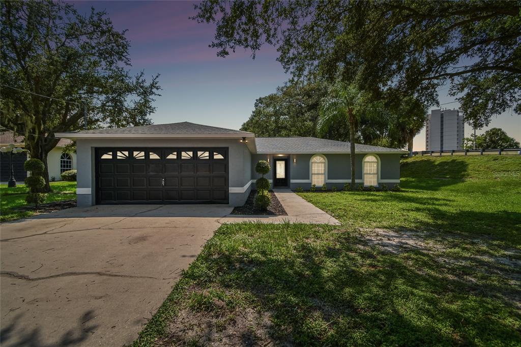 a view of house with yard and garage