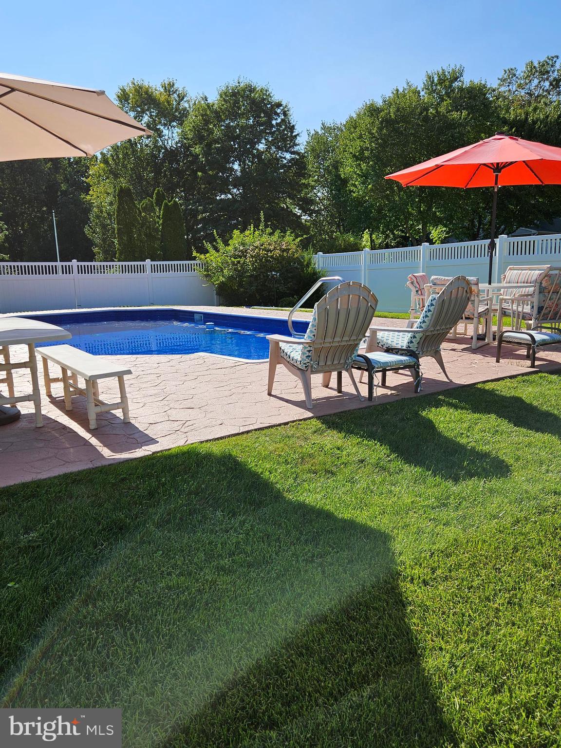 a view of a garden with lawn chairs under an umbrella