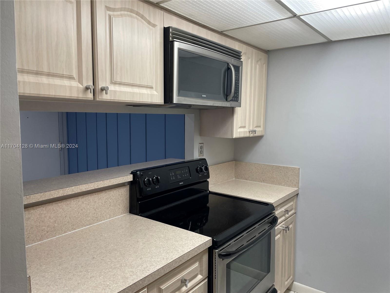 a kitchen with a sink a microwave and cabinets