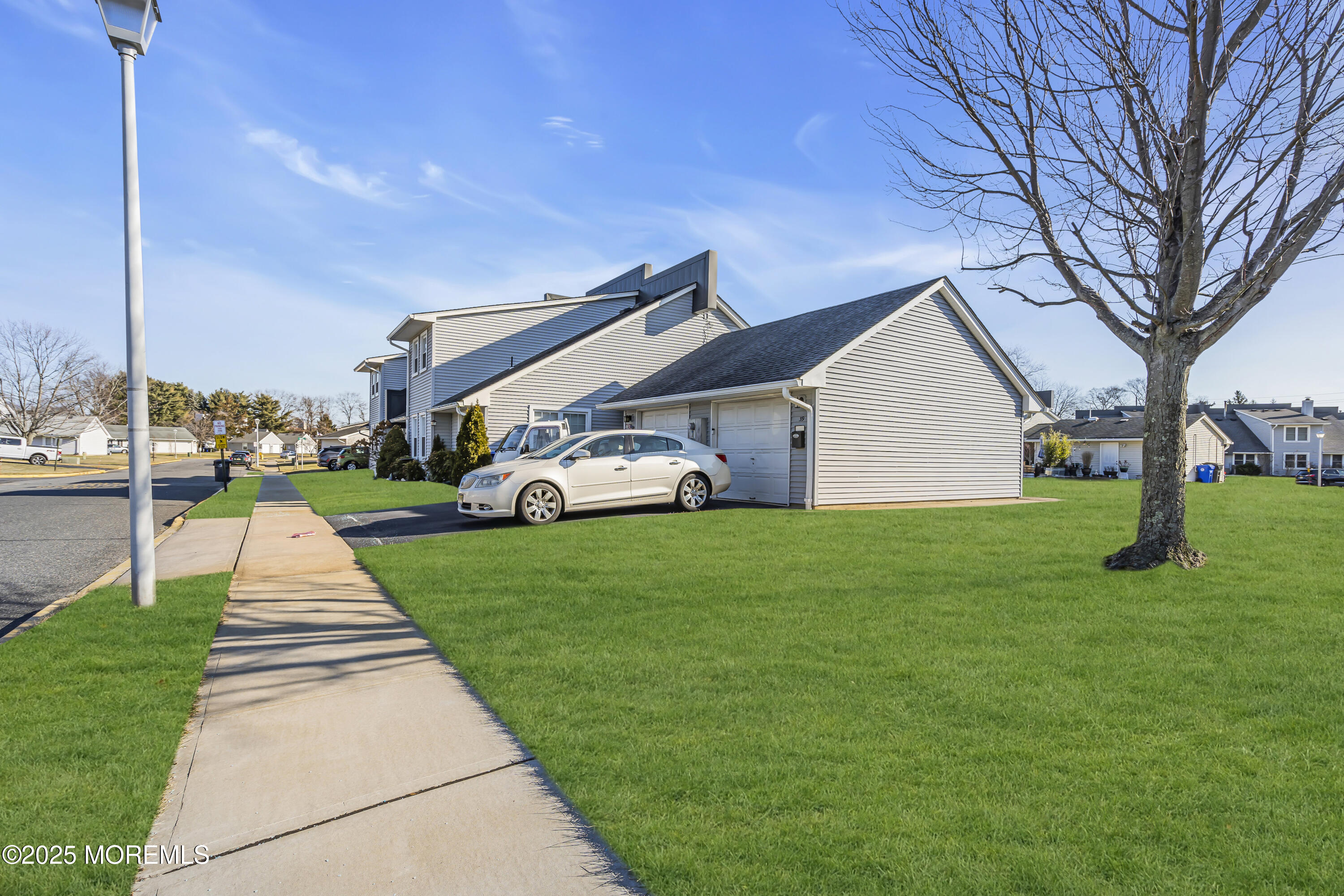 a front view of a house with a yard and trees