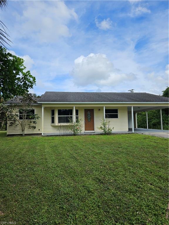 Single story home with a front yard and a carport