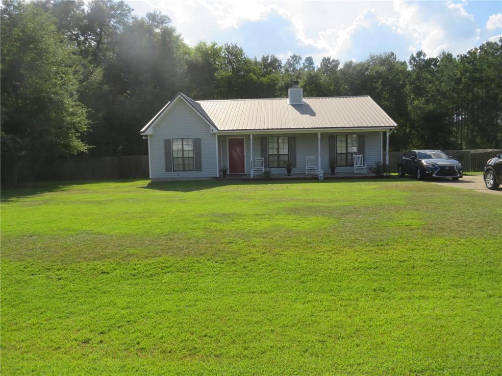 a front view of a house with yard and tree