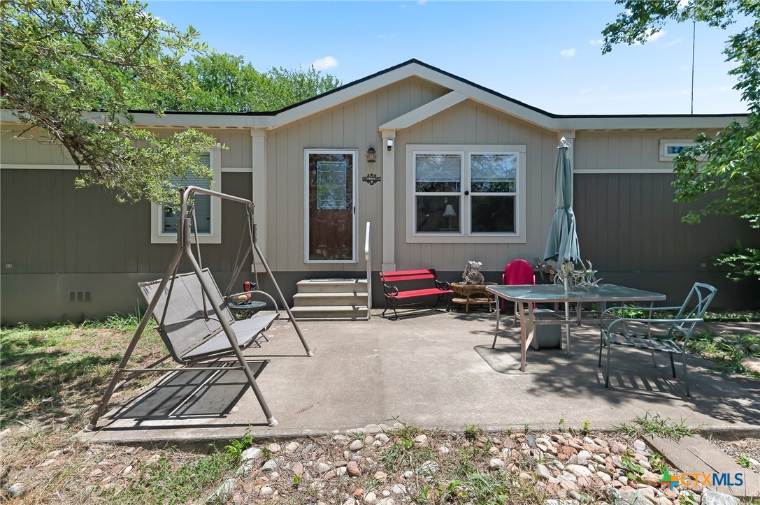 a view of a house with backyard sitting area and garden