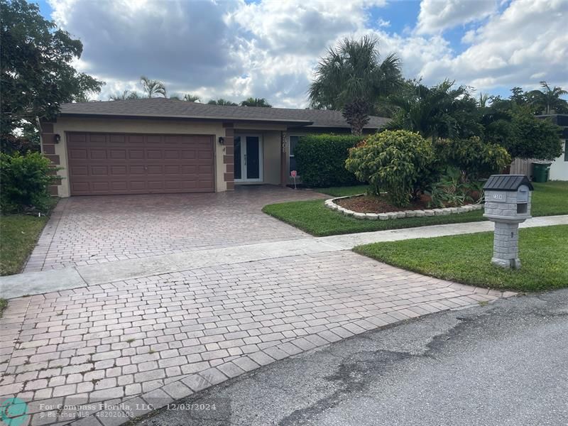 a front view of a house with a yard and a garage