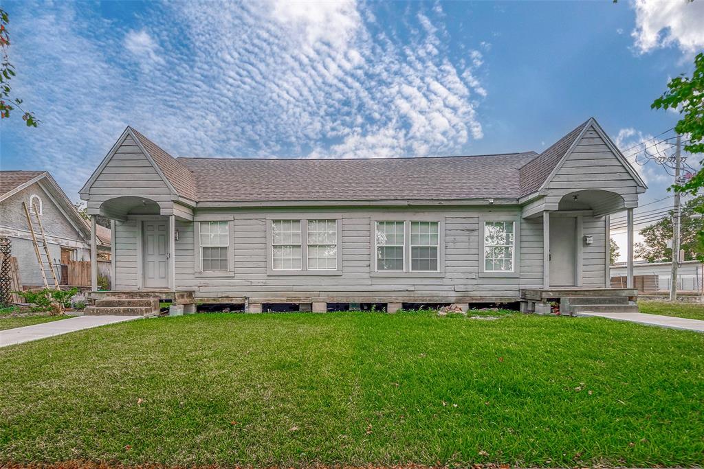 a front view of a house with a garden and yard