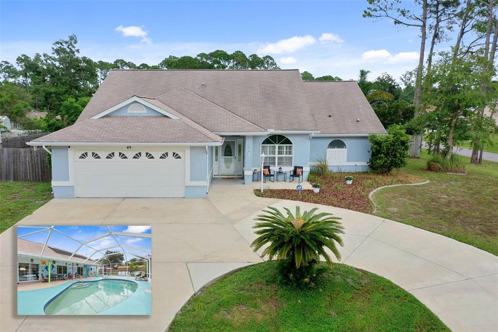 a view of swimming pool with outdoor seating and house in the background