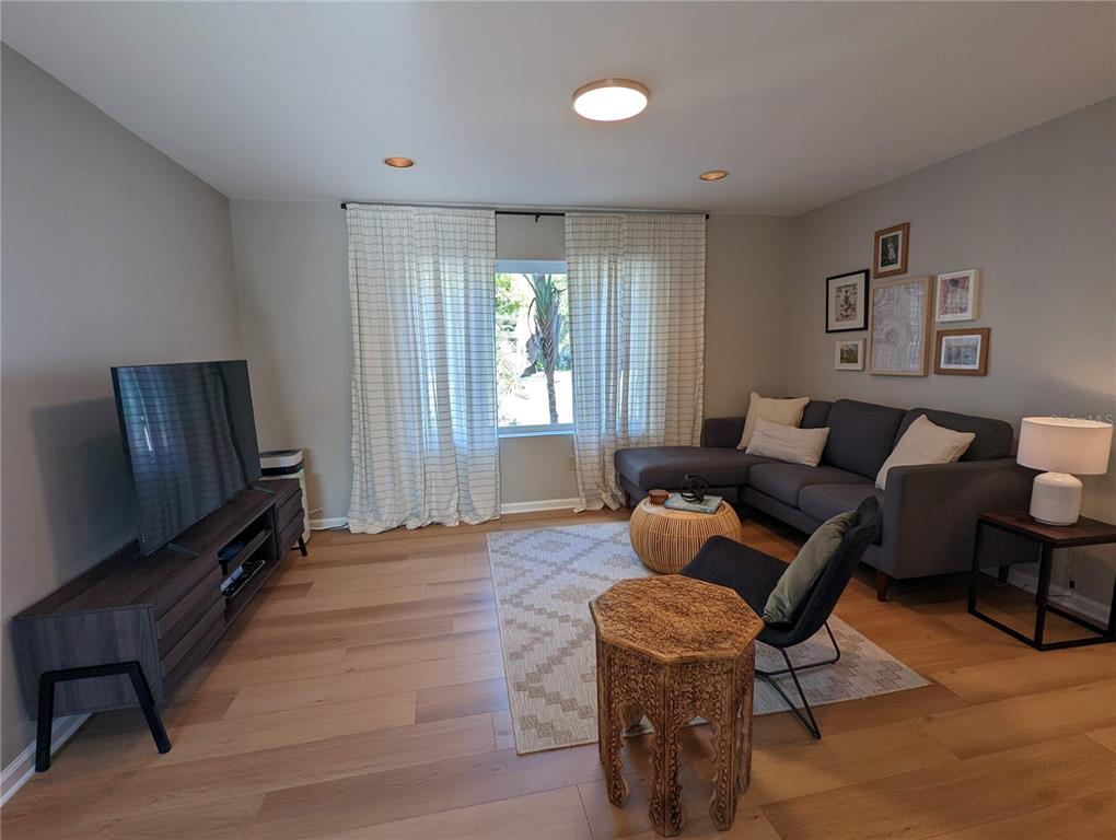 a living room with furniture a flat screen tv and a window