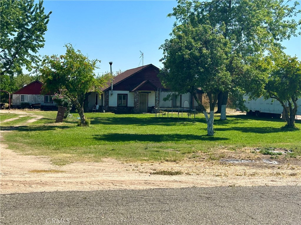 a front view of a house with a yard and trees