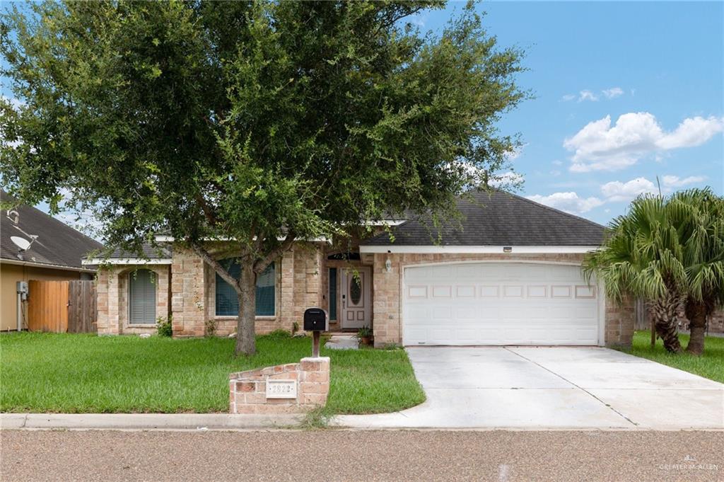 Ranch-style home featuring a garage and a front yard