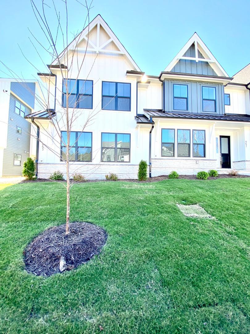 a front view of a house with a yard and trees