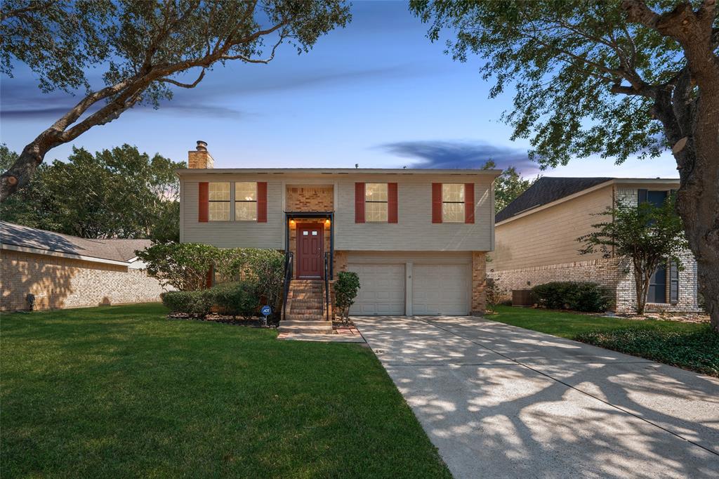 a front view of a house with a yard and tree