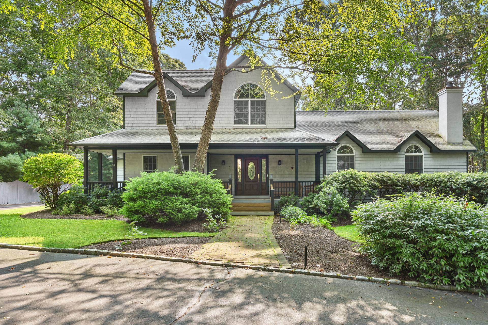 a front view of a house with a yard and potted plants