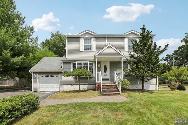 a front view of a house with a yard and trees