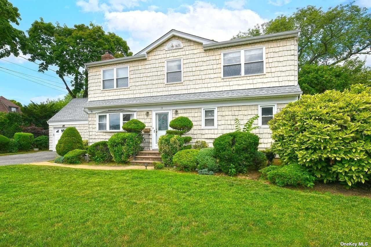 a front view of a house with plants and garden