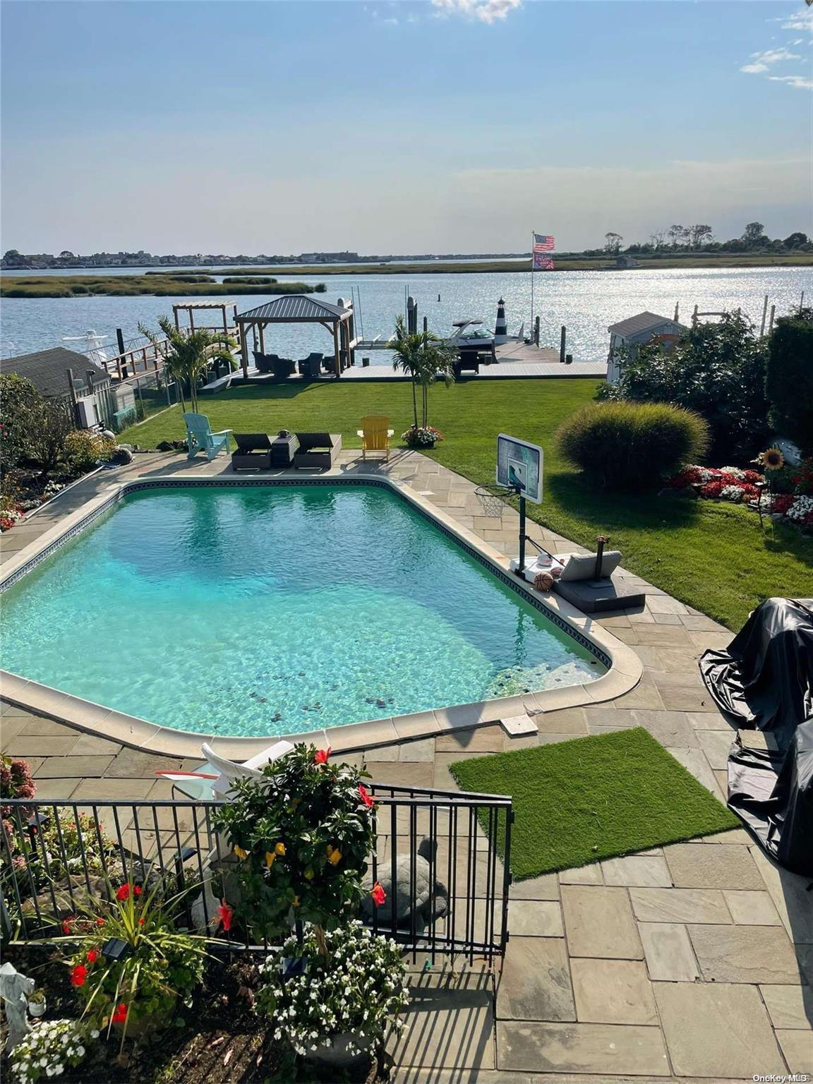 a view of a swimming pool with a yard and furniture